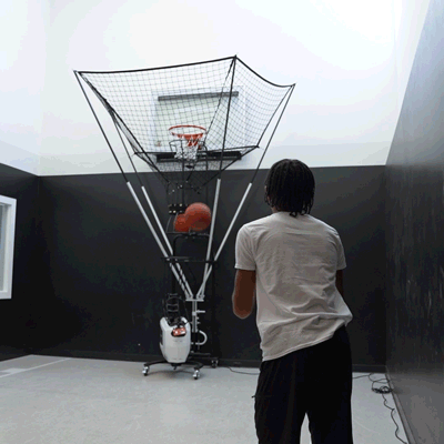 Player shooting on Dr. Dish Home basketball shooting machine in home gym